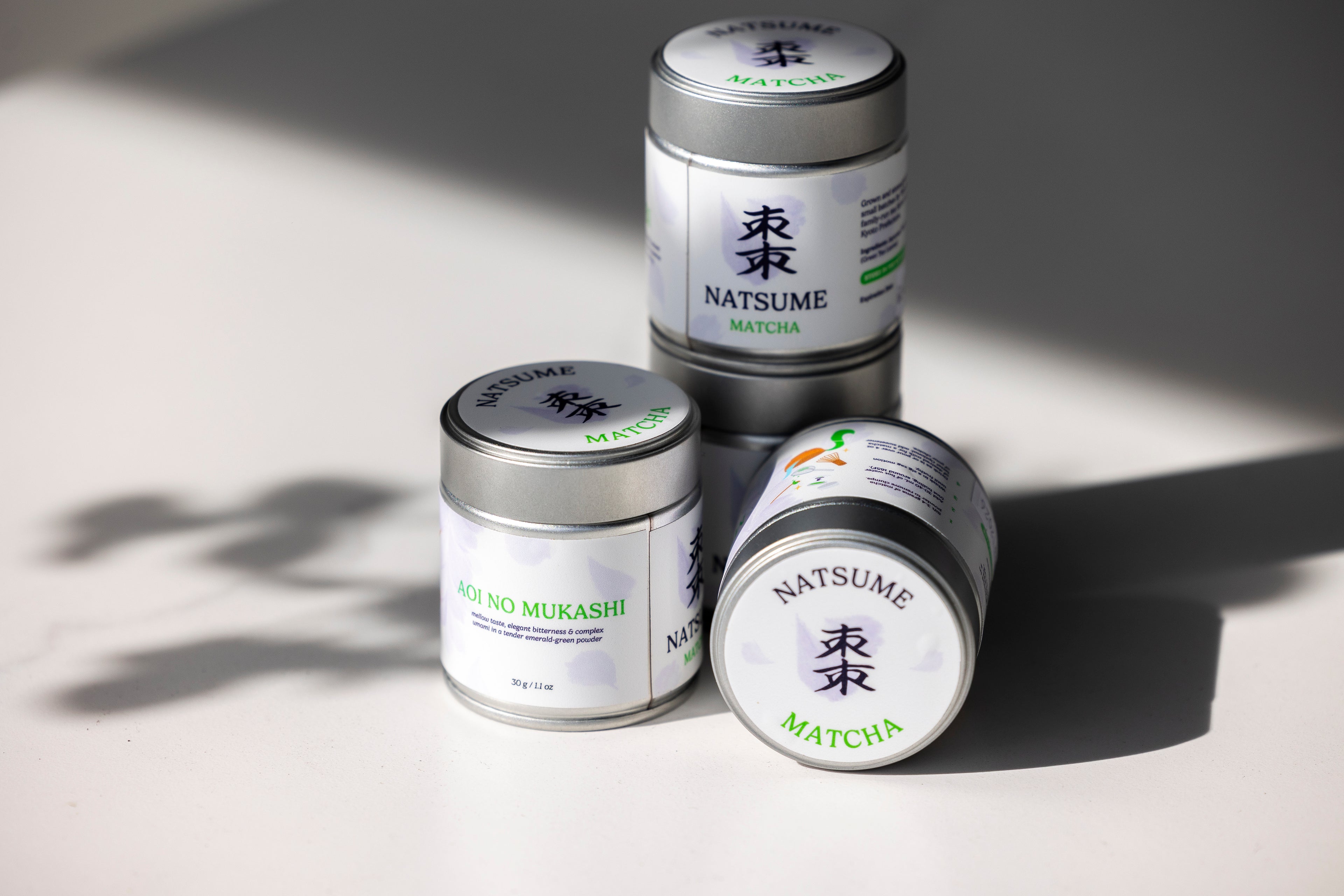 Natsume matcha products stacked on a light surface with soft shadows