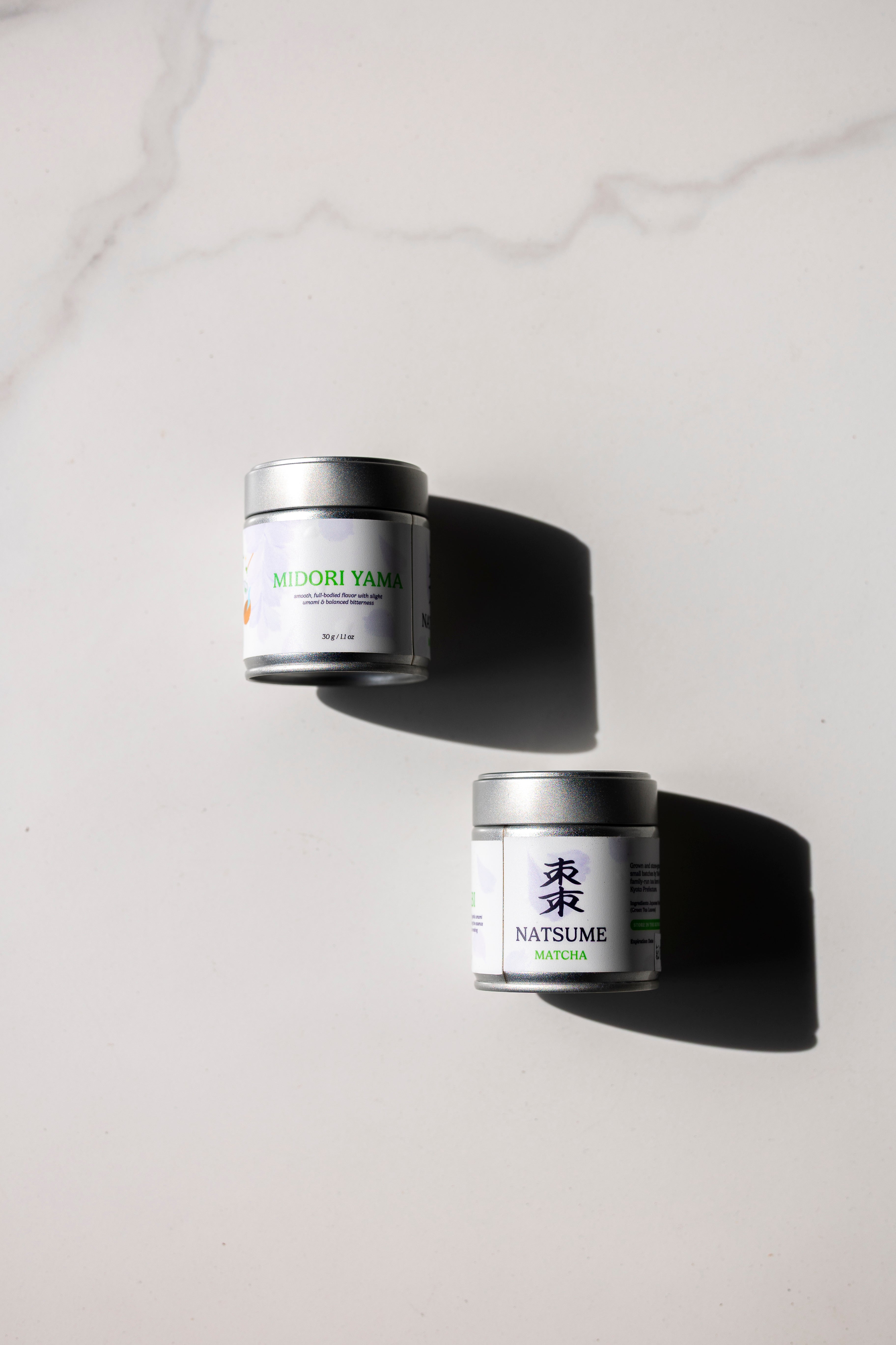 Two Natsume Matcha product overhead of the front and back of packaging